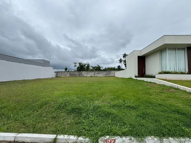 Fachada de uma residência moderna com um amplo gramado verde.
