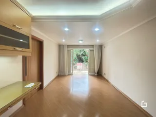 Hall de entrada com piso de madeira e portas de vidro.