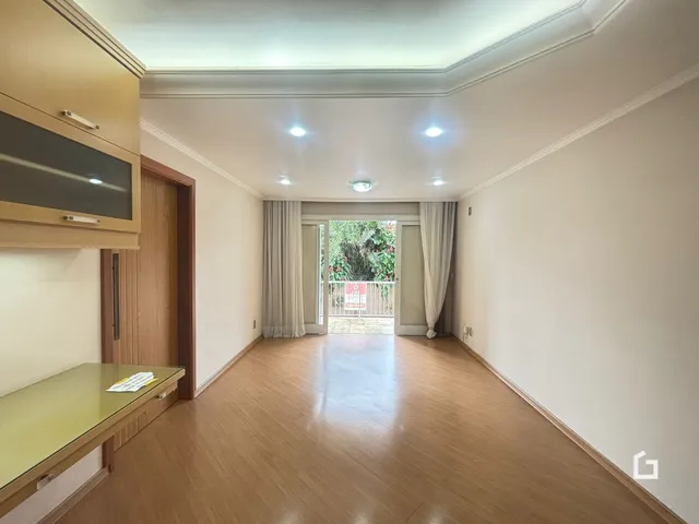 Hall de entrada com piso de madeira e portas de vidro.