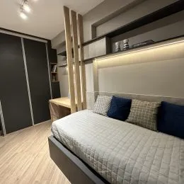 Quarto com cama e cabeceira em um ambiente interno.