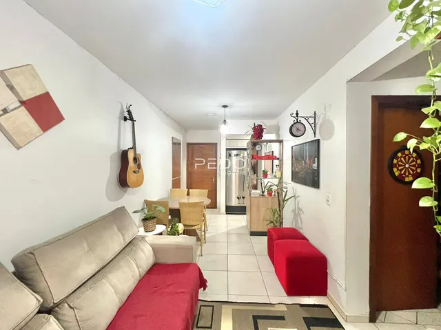 Sala de estar com sofá e bancos vermelhos em um imóvel no Brasil.