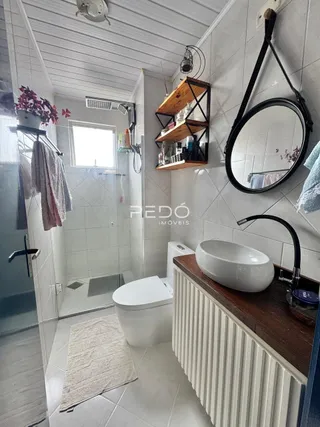 Foto de um banheiro com piso de cerâmica e paredes brancas.