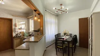 Foto de uma área de jantar com bancada de granito e móveis de madeira.