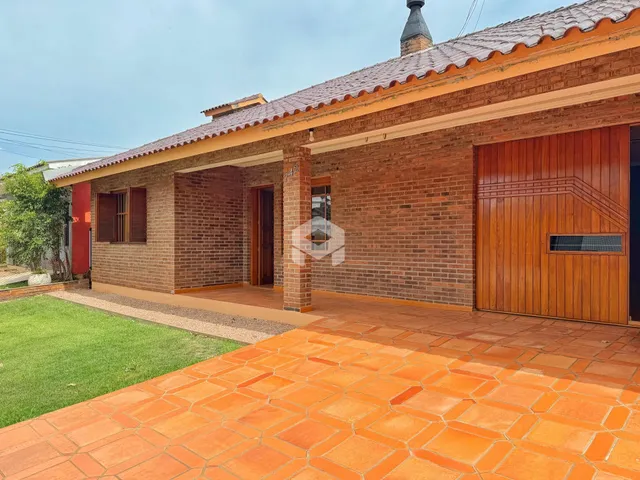 Fachada de uma casa com paredes de tijolo vermelho e telhado de telhas vermelhas.