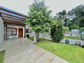 Fachada de uma residência em Lajeado, Brasil, com jardim e área pavimentada.