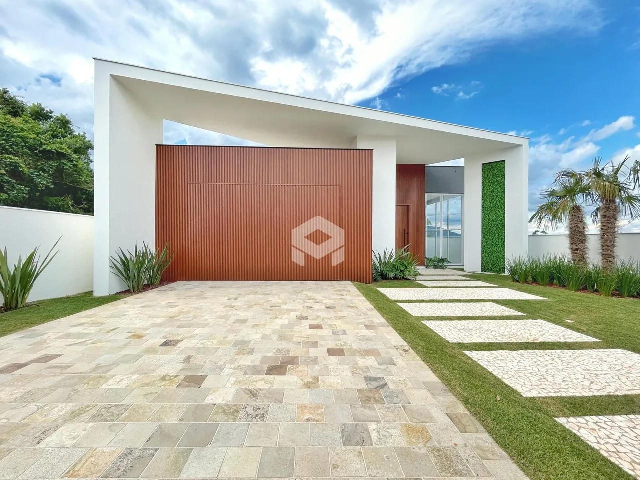 Fachada moderna de uma residência em Lajeado, Brasil, com jardim e entrada pavimentada.