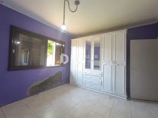 Quarto com paredes roxas e um grande armário branco.