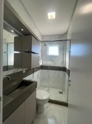 A foto mostra o interior de um banheiro com revestimento em mármore.