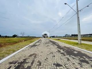 Vista da propriedade com acesso por estrada e área gramada.