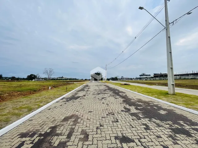 Vista da propriedade com acesso por estrada e área gramada.