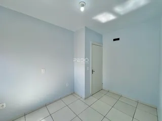 Interior de uma sala com paredes claras e piso de cerâmica.