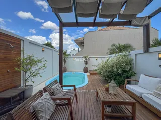 Vista de uma área externa com piscina e deck de madeira em Lajeado.