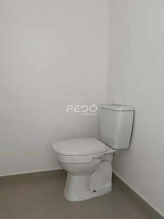 Foto de um banheiro vazio com um vaso sanitário branco.