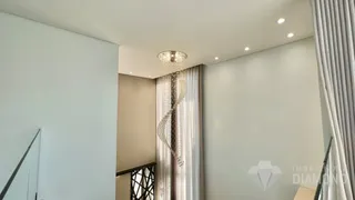 Interior de uma sala com cortinas e lustre decorativo.