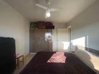 Quarto com armário de madeira e cama.