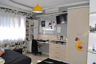 Interior de uma sala com armários embutidos e televisão.