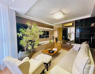 Sala de estar com sofá branco e plantas decorativas.