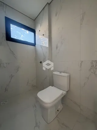 Banheiro com revestimento em mármore nas paredes e piso.