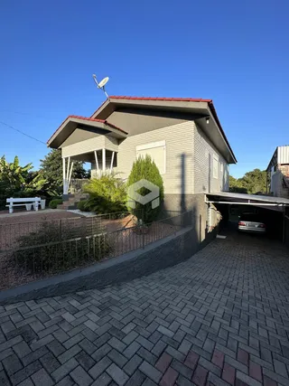 Vista externa de uma casa em Lajeado, Brasil, com jardim e garagem.