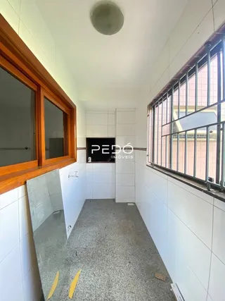 Vista interna de um corredor com paredes brancas e piso de concreto.