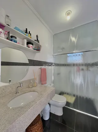 Foto de um banheiro com bancada de granito e box de vidro.