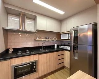 Cozinha moderna com armários de madeira e bancadas escuras.