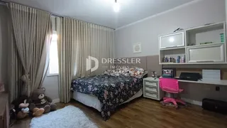 Quarto com cama e janela bem iluminada.