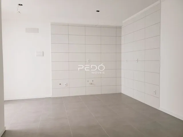 Imagem de um ambiente interno com paredes brancas e piso de cerâmica.