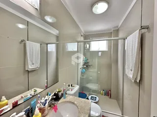 Foto de um banheiro moderno com revestimento cerâmico e box de vidro.