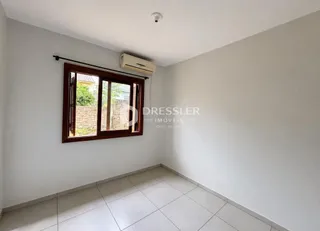Interior de um cômodo com parede branca e piso de cerâmica.
