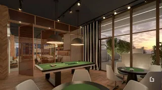 Ambiente interno com mesa de jogo de madeira e grandes janelas.