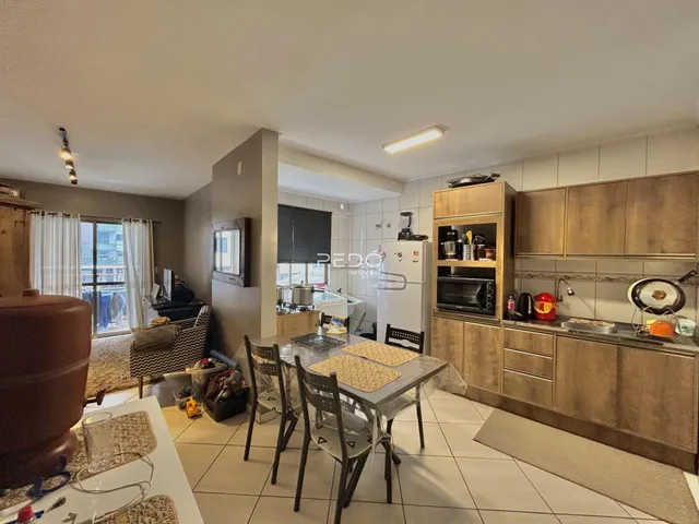 Sala de estar e cozinha com mesa de jantar em um imóvel no Brasil.