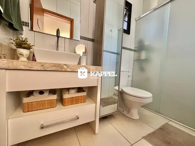 Banheiro moderno com bancada e box de vidro.