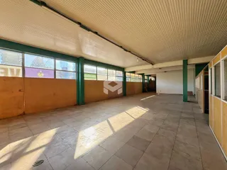 Vista interna de um espaço com piso de cerâmica e paredes em tom alaranjado.