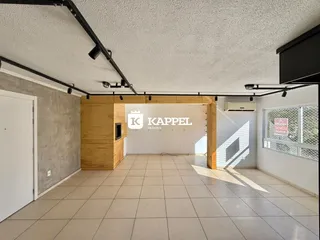 Foto de um ambiente interno amplo com piso de cerâmica e estrutura de madeira.