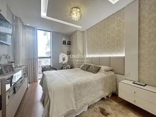 Quarto com cama e paredes claras em um imóvel.