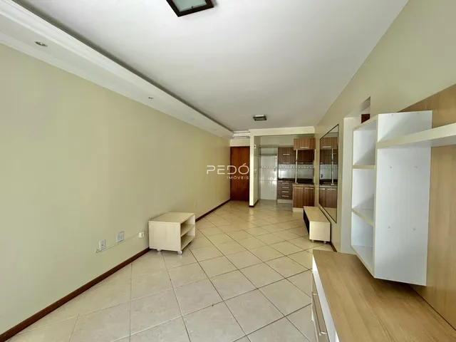Corredor com piso de cerâmica claro e paredes claras.