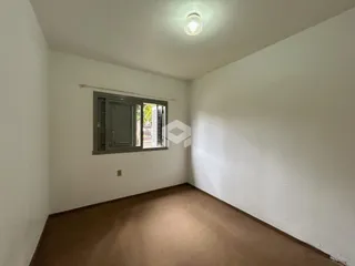 Foto interna de uma sala com piso de cor marrom.