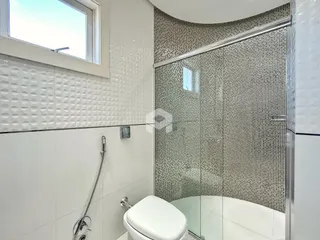 Banheiro com box de vidro e revestimento moderno.