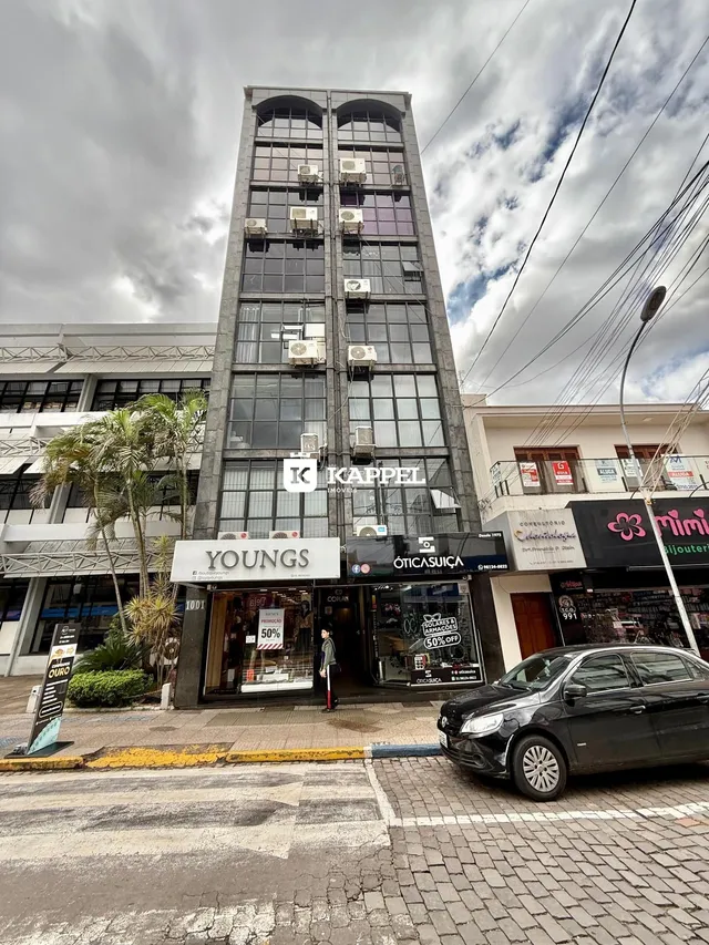 Fachada de um prédio comercial em Lajeado, Brasil, com várias lojas no térreo.
