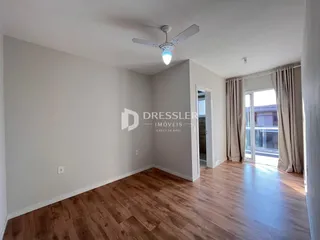 Foto de um ambiente interno com piso de madeira e paredes brancas.