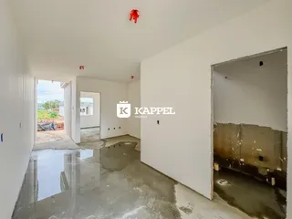 Foto de um corredor interno com piso molhado e paredes brancas em uma propriedade.