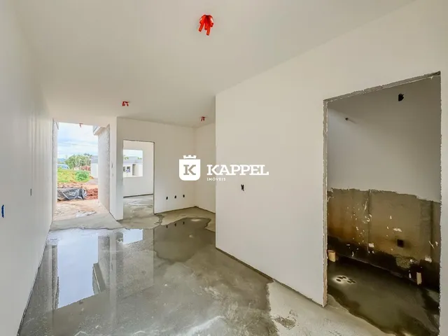 Foto de um corredor interno com piso molhado e paredes brancas em uma propriedade.