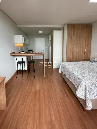 Uma sala de estar com área de jantar e cozinha em um imóvel.