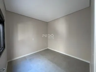 Vista interna de um corredor com paredes claras e piso de cerâmica.