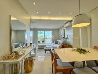 Sala de estar moderna com piso de porcelanato claro e grande janela de vidro.