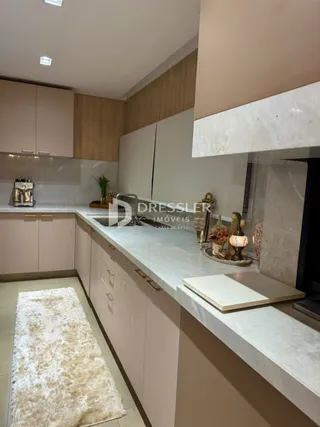 Cozinha moderna com armários brancos e bancadas claras.