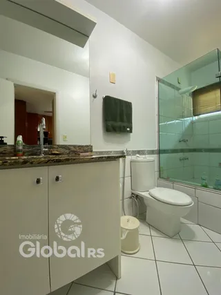 Foto de um banheiro interno com piso cerâmico e box de vidro.