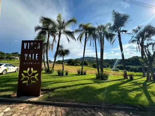 Vista externa mostrando um gramado verde e palmeiras em Lajeado.