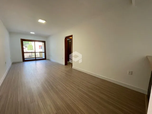 Ambiente interno com piso de madeira e paredes brancas.